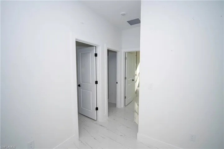 Hall featuring baseboards and light marble finish flooring