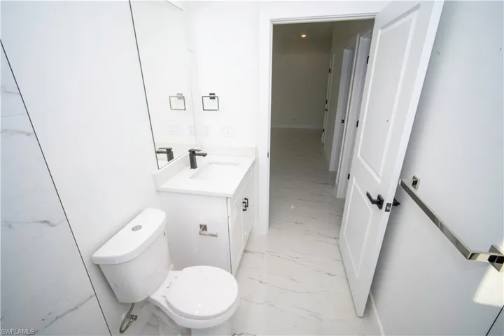 Half bathroom featuring light marble finish floors and vanity