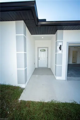 Property entrance featuring stucco siding and a patio