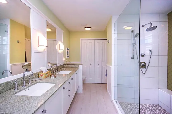 Bathroom with vanity, toilet, and tiled shower