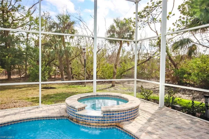 View of pool with a lanai and an in ground hot tub
