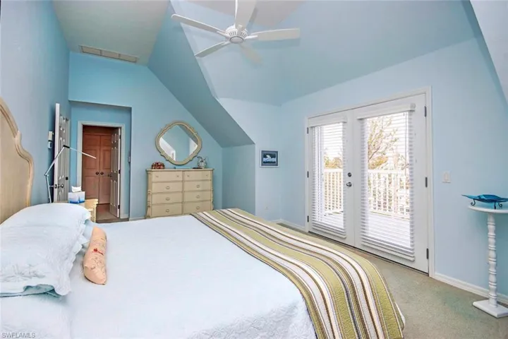Bedroom with access to exterior, carpet floors, vaulted ceiling, and ceiling fan
