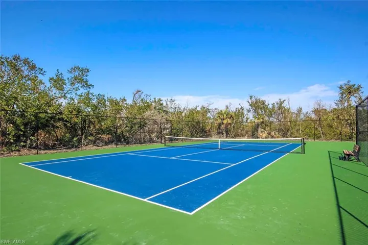 View of tennis court with basketball hoop
