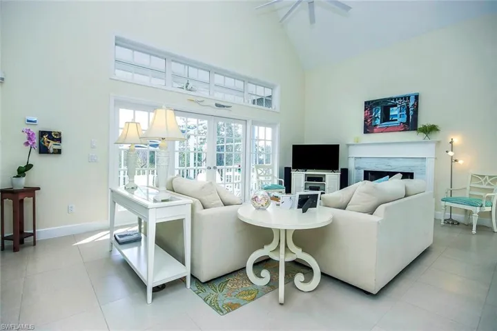 Tiled living room featuring french doors and high vaulted ceiling
