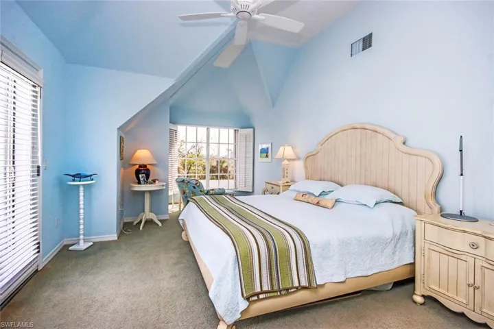 Bedroom with ceiling fan, light carpet, and lofted ceiling