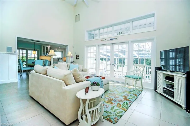 Tiled living room with a high ceiling and french doors