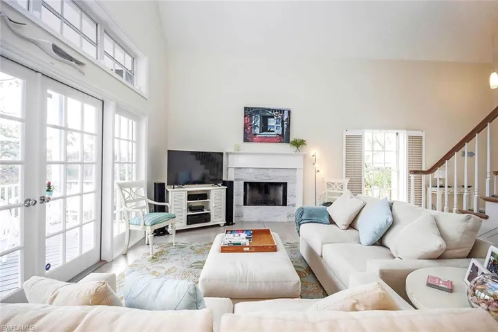 Living room featuring a high end fireplace, a high ceiling, and tile patterned floors