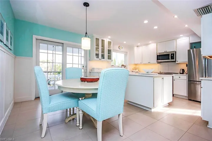 Kitchen featuring white cabinets, stainless steel appliances, and hanging light fixtures