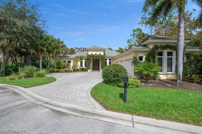 garage, decorative driveway, and a front lawn