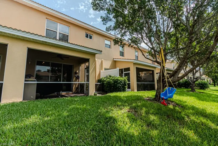 Rear view of property with ceiling fan, a sunroom, and a yard