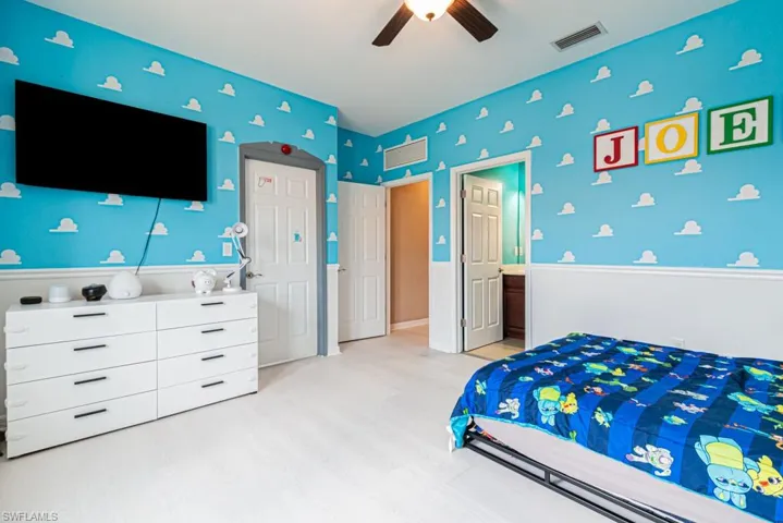 Bedroom featuring ensuite bath, light wood-type flooring, and ceiling fan