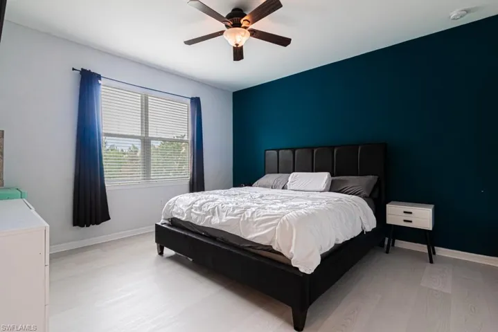 Bedroom with light hardwood / wood-style flooring and ceiling fan