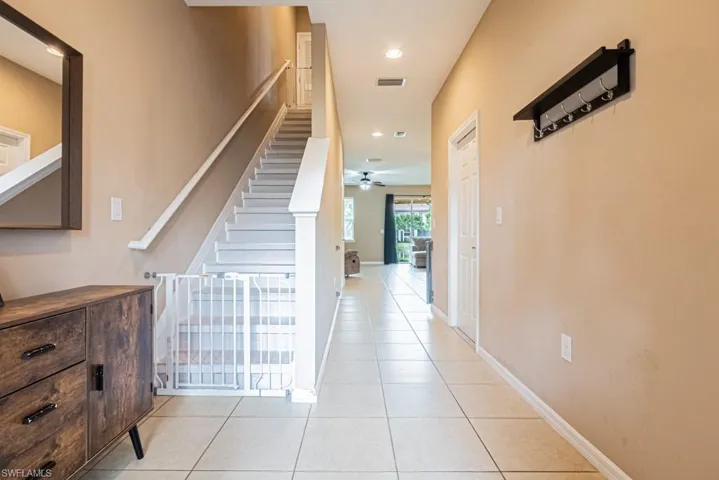 Staircase featuring ceiling fan and tile patterned floors