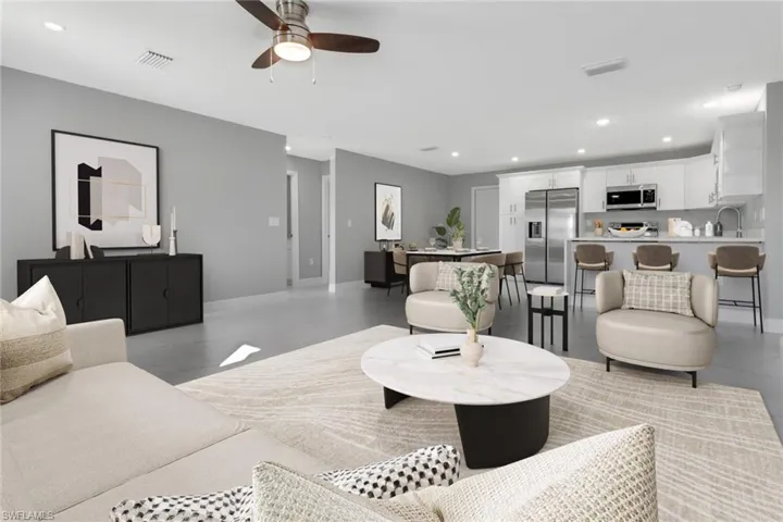 Living room featuring ceiling fan and sink