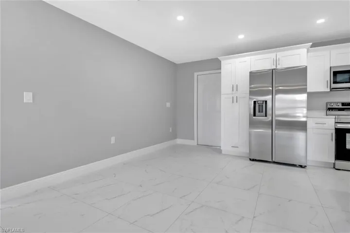 Kitchen with white cabinetry and appliances with stainless steel finishes