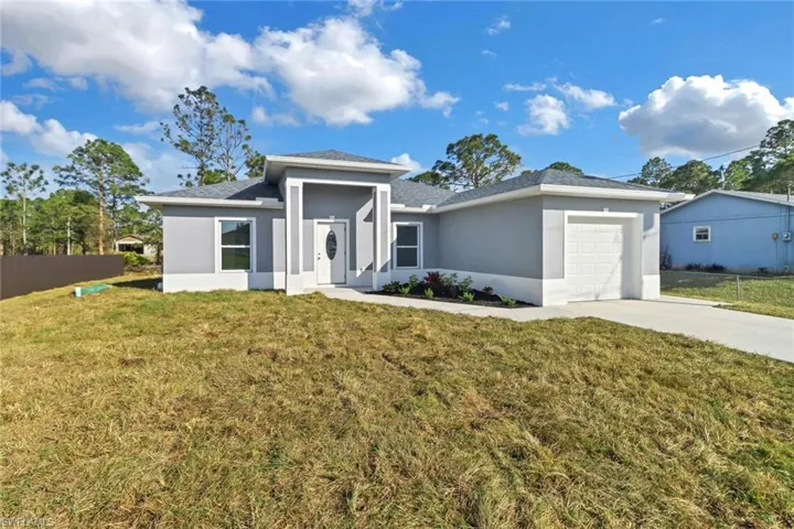 View of front of house featuring a garage and a front lawn