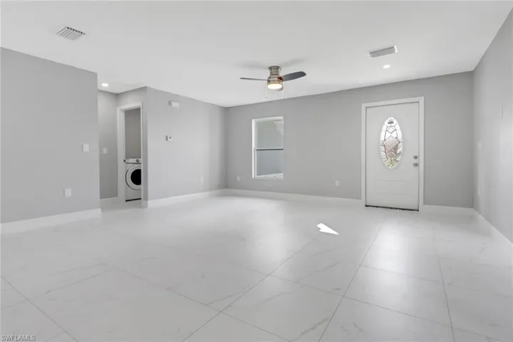 Foyer entrance with ceiling fan and washer / dryer