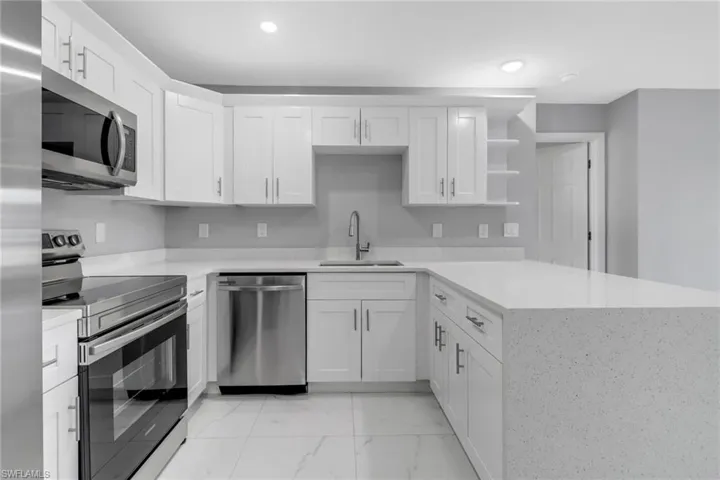 Kitchen featuring white cabinetry, appliances with stainless steel finishes, sink, and kitchen peninsula