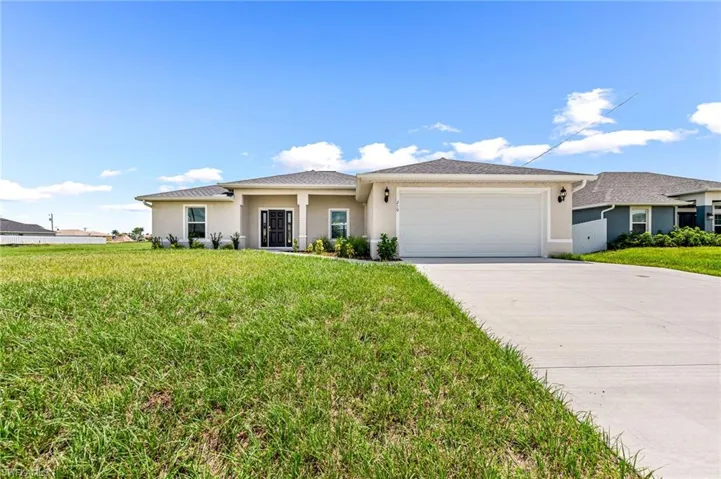 Prairie-style house with driveway, a front yard, an attached garage, and stucco siding