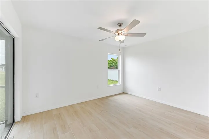 Spare room featuring baseboards, a ceiling fan, and light wood-style floors