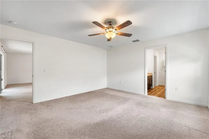 Carpeted spare room featuring ceiling fan