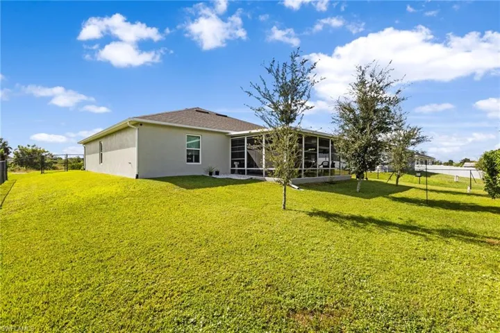 Rear view of house featuring a lawn and a sunroom