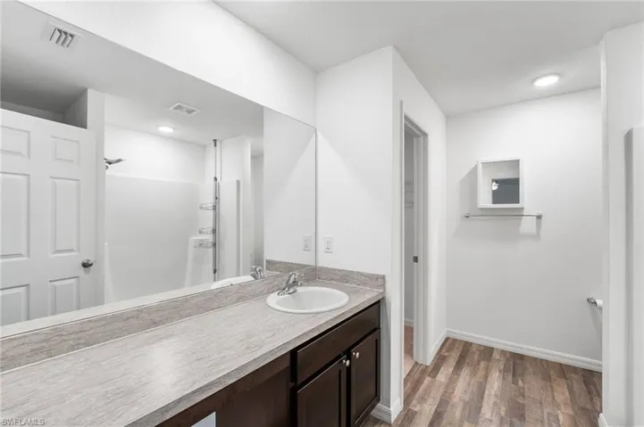 Bathroom with a shower, hardwood / wood-style floors, and vanity