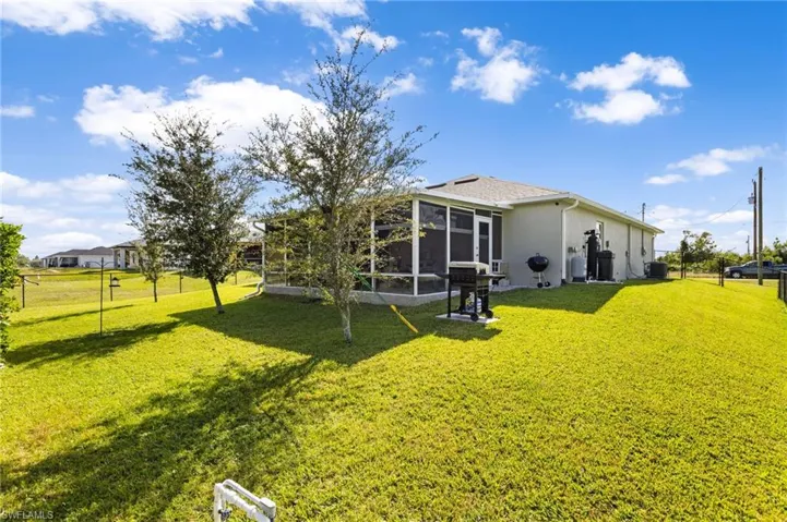 Back of house featuring a yard, central AC, and a sunroom