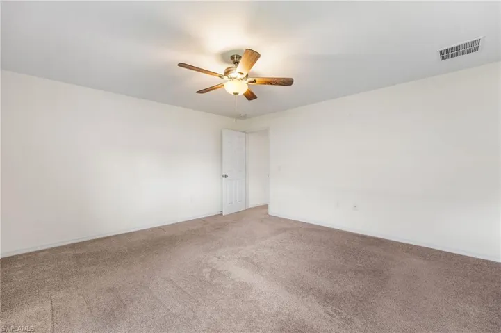 Carpeted spare room with ceiling fan