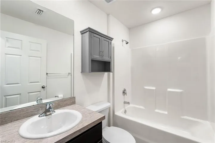 Full bathroom featuring vanity, toilet, and shower / washtub combination