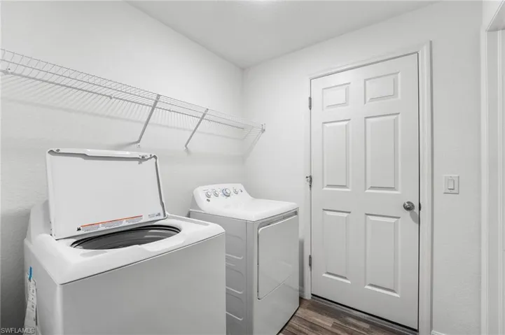 Laundry room featuring dark hardwood / wood-style floors and washing machine and clothes dryer