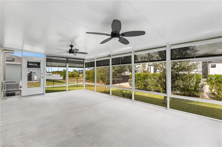 Unfurnished sunroom featuring ceiling fan and cooling unit