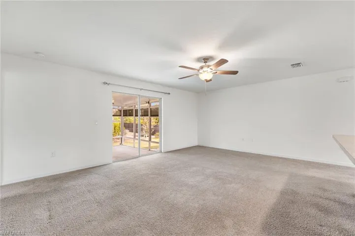Unfurnished room with ceiling fan and carpet