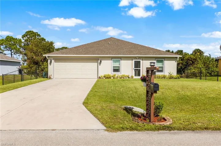 Single story home featuring a front yard and a garage