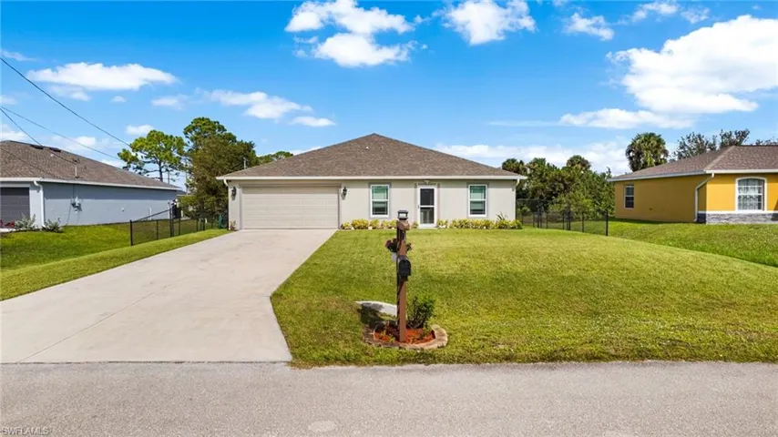 Ranch-style home featuring a garage and a front yard