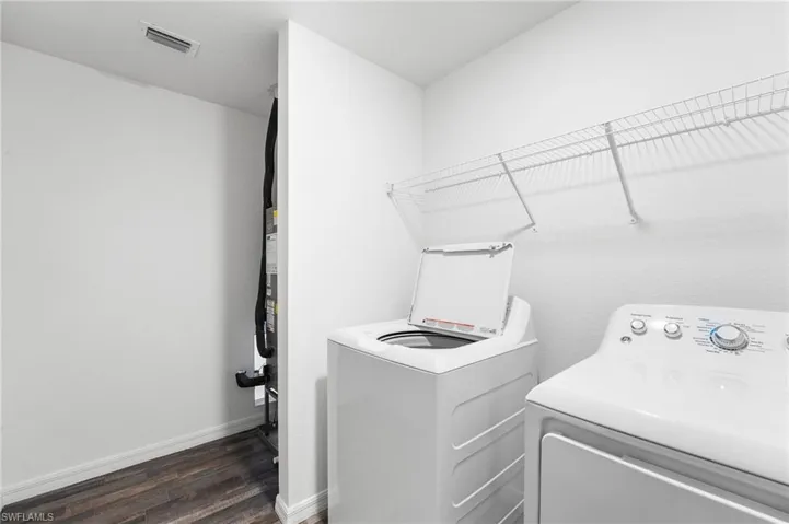 Washroom featuring dark hardwood / wood-style floors and washer and clothes dryer