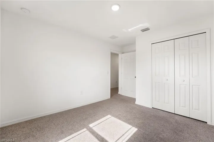Unfurnished bedroom with a closet and carpet floors