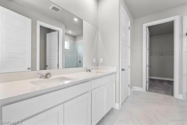 Bathroom featuring vanity and a shower with shower door