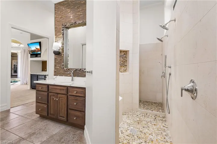 The walk through shower floor has a sitting bench, 2 overhead shower heads, floor to ceiling tile and Mosaic Stone Pebble! Relaxing in the warmth of the steam at the end of a day of work is priceless.