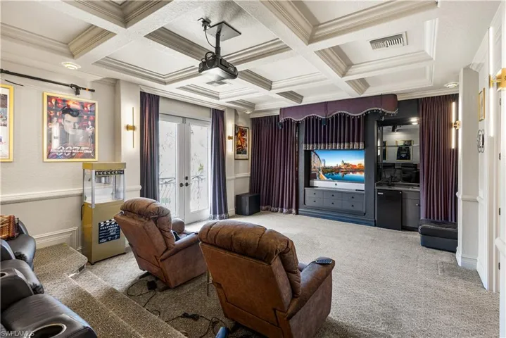 This is a fabulous theatre room.Coffered ceilings. Refridgerator, sink.