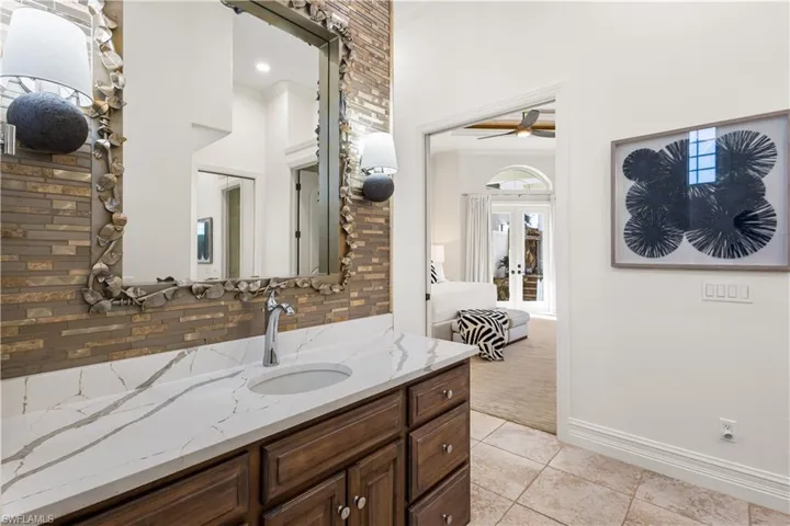 Separate his and hers vanities with quartz countertops. Spectacular backsplash!