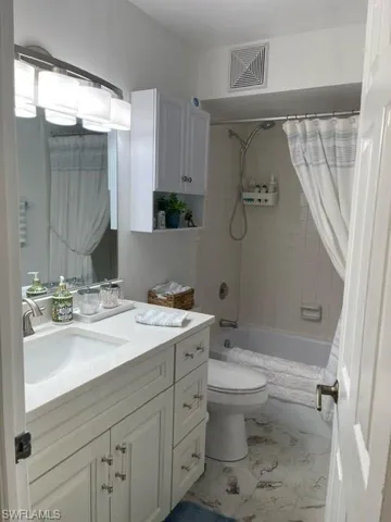 HALL BATHROOM HAS A BEAUTIFUL, WHITE WOOD VANITY, GORGEOUS TILE FLOORING AND NEW LIGHTING
