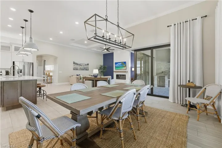 Dining area featuring ornamental molding, arched walkways, a chandelier, and recessed lighting