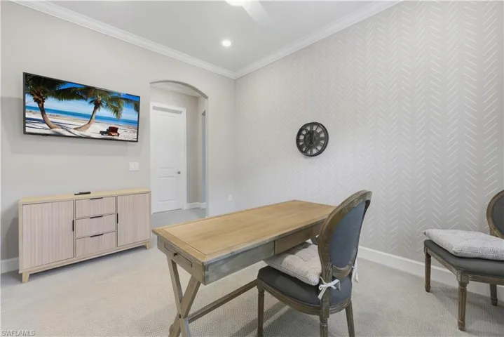 Office featuring arched walkways, ornamental molding, light carpet, recessed lighting, and an accent wall