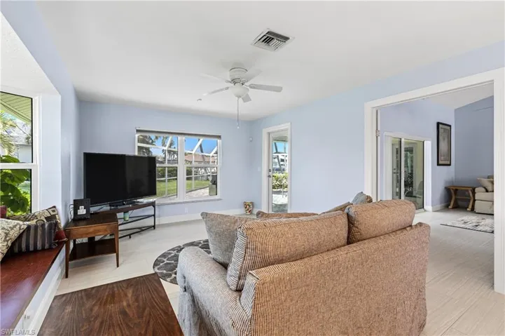 Living area with a ceiling fan and baseboards