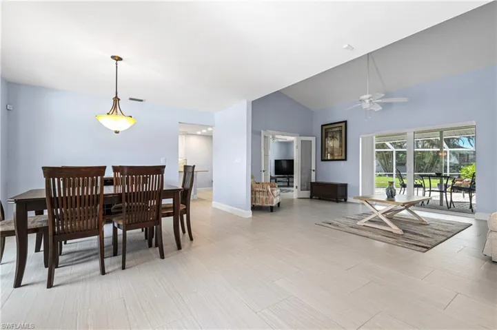 Dining space with a ceiling fan and high vaulted ceiling