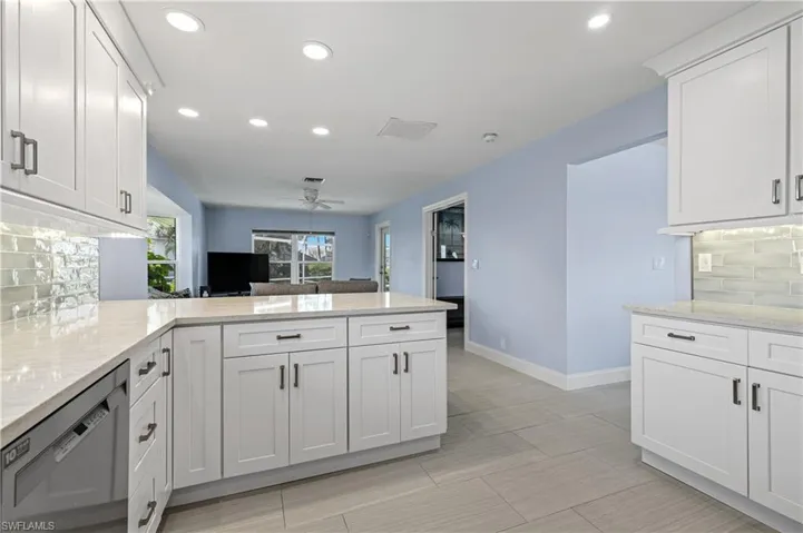 Kitchen with stainless steel dishwasher, ceiling fan, backsplash, a peninsula, and recessed lighting