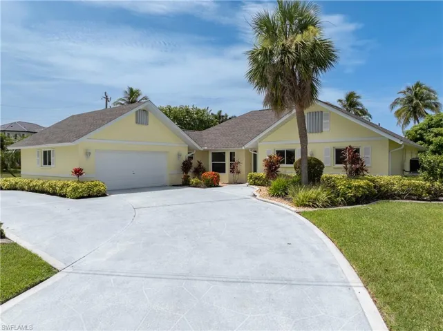Ranch-style house with a front yard, a garage, concrete driveway, stucco siding, and roof with shingles