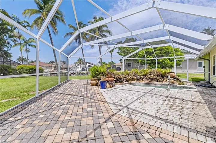 View of patio featuring glass enclosure and an outdoor pool