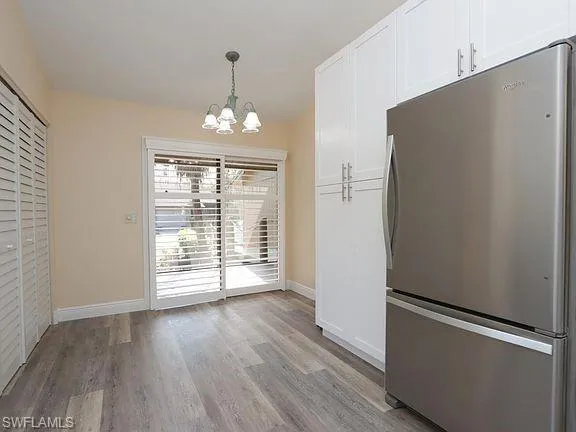 Unfurnished dining area featuring a chandelier and light wood-style floors